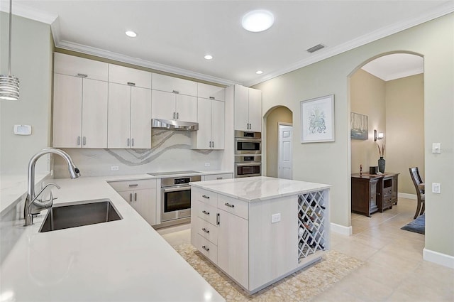 kitchen featuring sink, white cabinets, decorative backsplash, a center island, and black electric stovetop