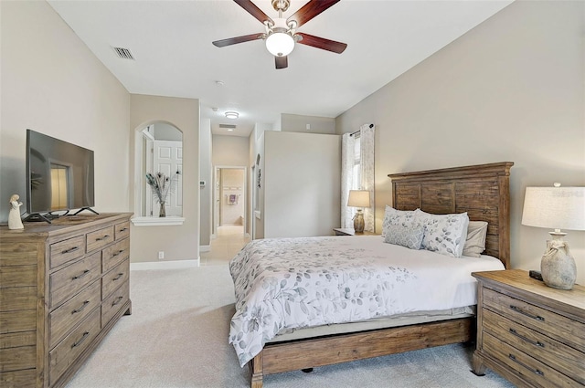 bedroom featuring ceiling fan, connected bathroom, and light carpet