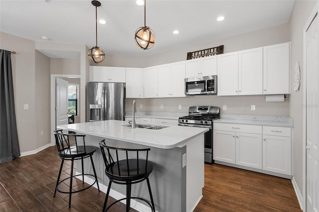 kitchen with sink, dark hardwood / wood-style floors, appliances with stainless steel finishes, and pendant lighting