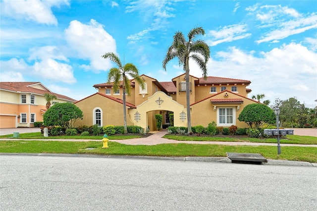 mediterranean / spanish-style home with a front yard