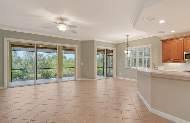 kitchen featuring crown molding, a wealth of natural light, and light tile patterned flooring