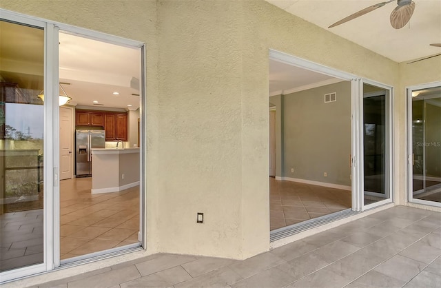 entrance to property featuring a patio and ceiling fan