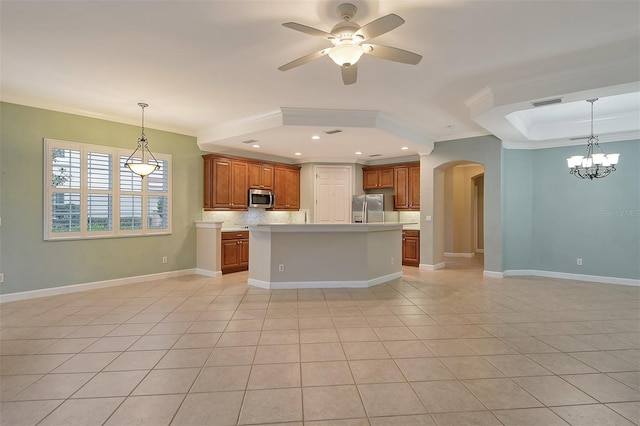 kitchen featuring decorative light fixtures, ornamental molding, stainless steel appliances, a kitchen island with sink, and decorative backsplash