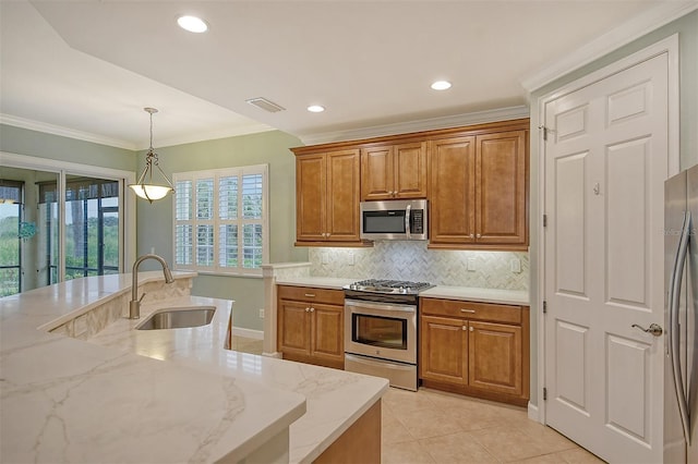 kitchen featuring sink, hanging light fixtures, appliances with stainless steel finishes, light stone countertops, and backsplash