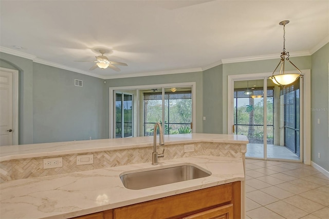 kitchen with a wealth of natural light, sink, pendant lighting, and light tile patterned floors