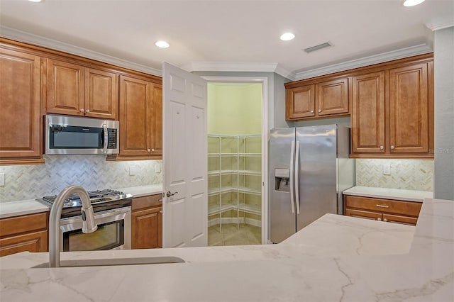 kitchen featuring light stone countertops, appliances with stainless steel finishes, ornamental molding, and decorative backsplash