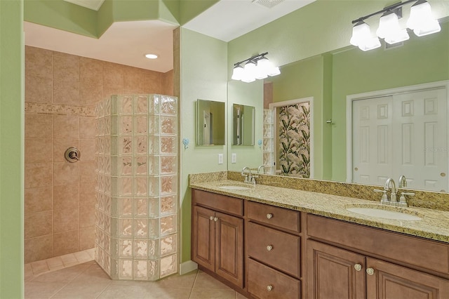 bathroom featuring tile patterned floors, vanity, and a tile shower