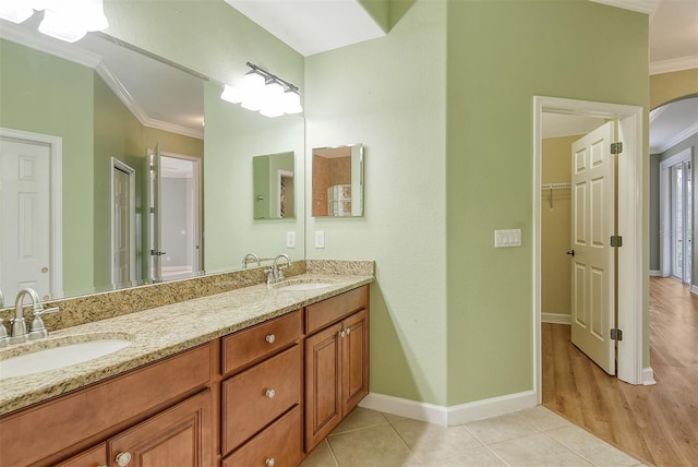 bathroom featuring tile patterned flooring, vanity, and crown molding