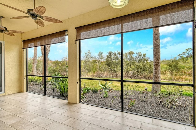 unfurnished sunroom featuring ceiling fan