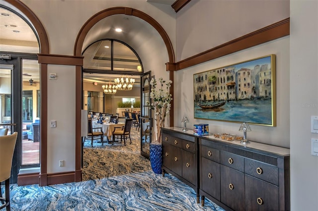 interior space with dark brown cabinetry, a notable chandelier, and carpet floors