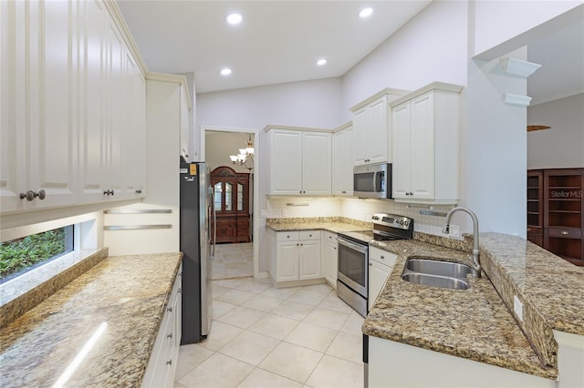 kitchen featuring stone counters, sink, white cabinets, kitchen peninsula, and stainless steel appliances