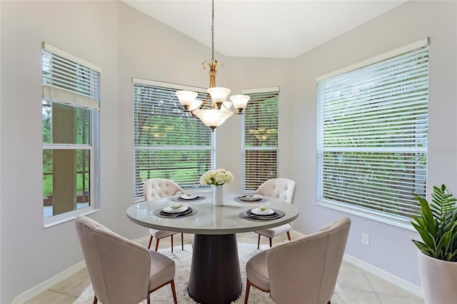 tiled dining area featuring lofted ceiling and a notable chandelier