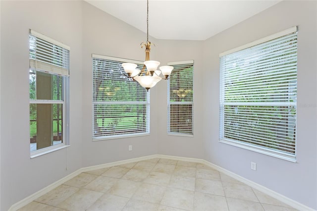 empty room featuring a chandelier and vaulted ceiling