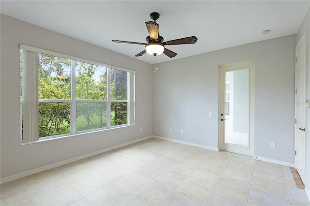 tiled empty room featuring ceiling fan