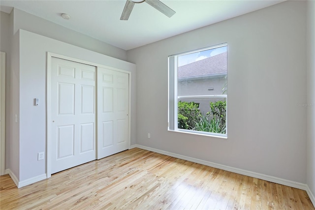 unfurnished bedroom featuring light hardwood / wood-style flooring, ceiling fan, and a closet