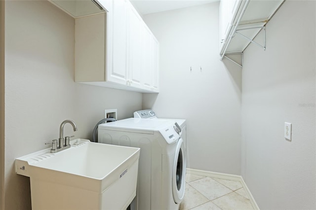 washroom with cabinets, washer and clothes dryer, sink, and light tile patterned floors