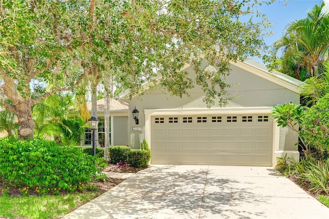 11662 Old Cypress Cv, Parrish, FL 34219 - view of front of home featuring concrete driveway, a garage, and stucco siding