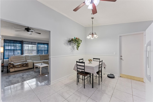 dining room with ceiling fan with notable chandelier, ornamental molding, light tile patterned floors, and a textured ceiling