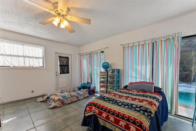 bedroom with ceiling fan, a textured ceiling, and tile patterned flooring