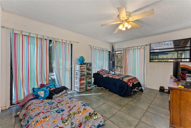 bedroom featuring ceiling fan, multiple windows, and a textured ceiling