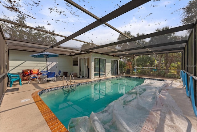 view of pool featuring glass enclosure and a patio area