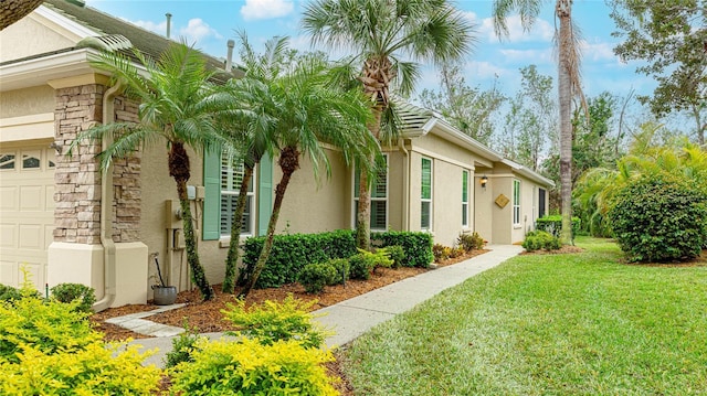 view of side of property featuring a yard and a garage