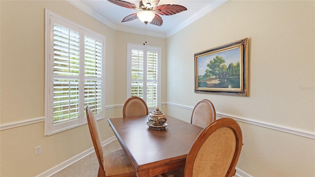 tiled dining space with ceiling fan and ornamental molding