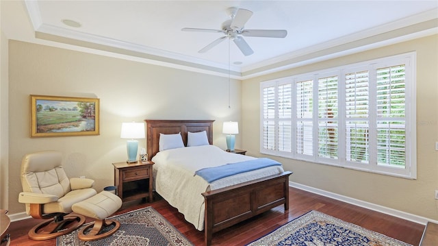 bedroom with dark hardwood / wood-style floors, ornamental molding, a raised ceiling, and ceiling fan