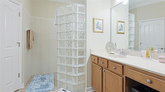 bathroom featuring vanity, ornamental molding, and tiled shower