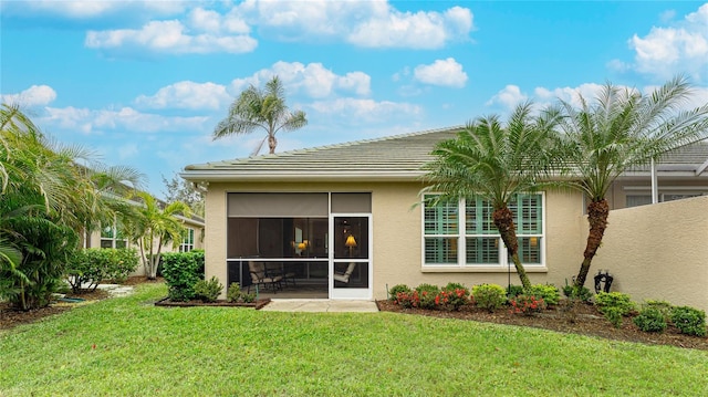 back of house featuring a yard and a sunroom