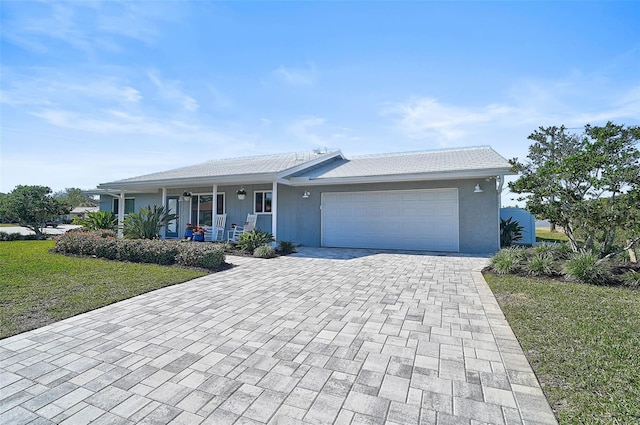 single story home featuring a garage, a porch, and a front yard