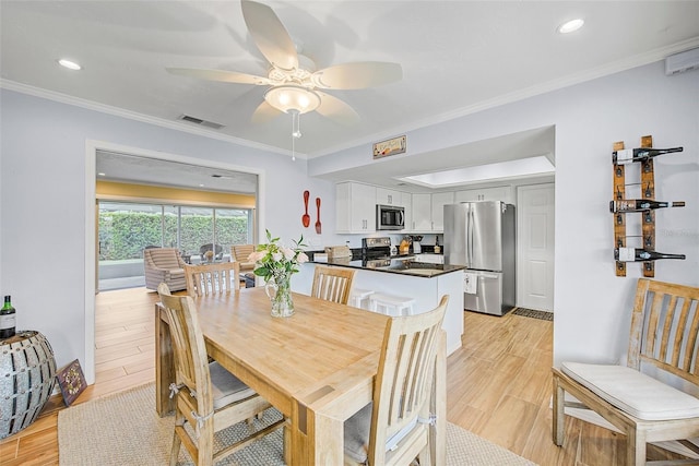 dining area featuring crown molding, ceiling fan, and light wood-type flooring