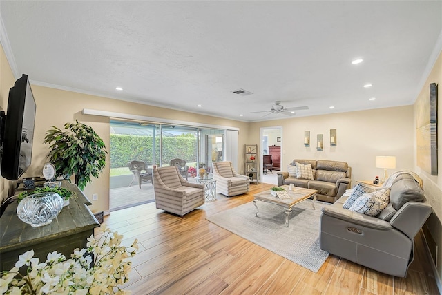 living room with crown molding, ceiling fan, and light hardwood / wood-style floors