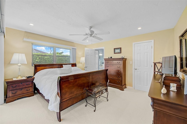 bedroom featuring light carpet, a textured ceiling, and ceiling fan