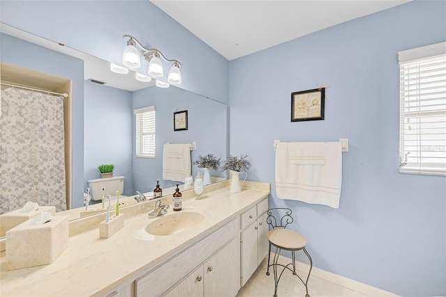 bathroom featuring vanity, tile patterned flooring, toilet, and a healthy amount of sunlight