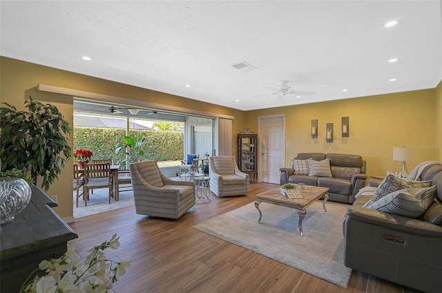 living room with hardwood / wood-style floors, a textured ceiling, and ceiling fan