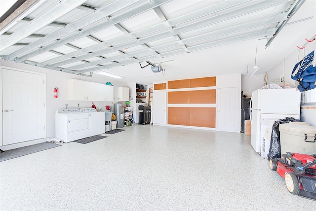 garage with separate washer and dryer, a garage door opener, electric water heater, and white fridge