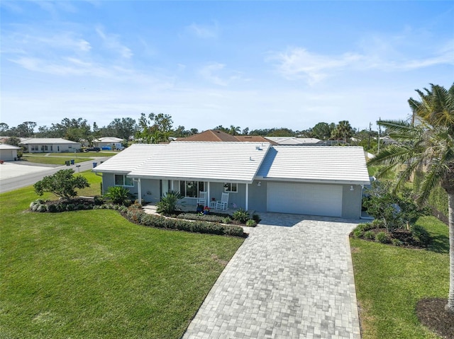 single story home featuring a porch, a garage, and a front lawn