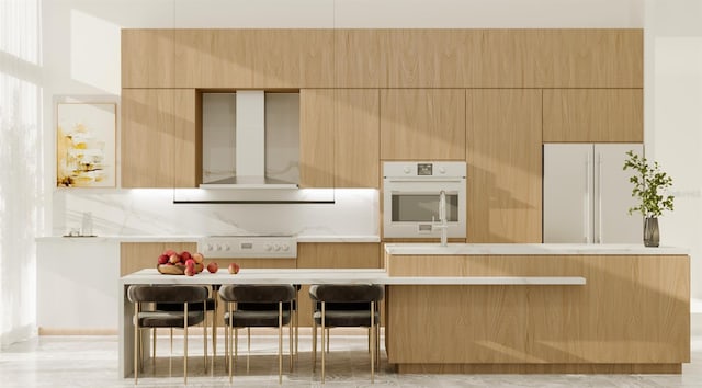 kitchen with white appliances, decorative backsplash, and wall chimney exhaust hood