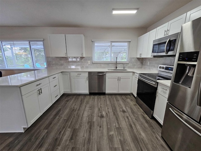 kitchen with stainless steel appliances, sink, white cabinets, and dark hardwood / wood-style floors