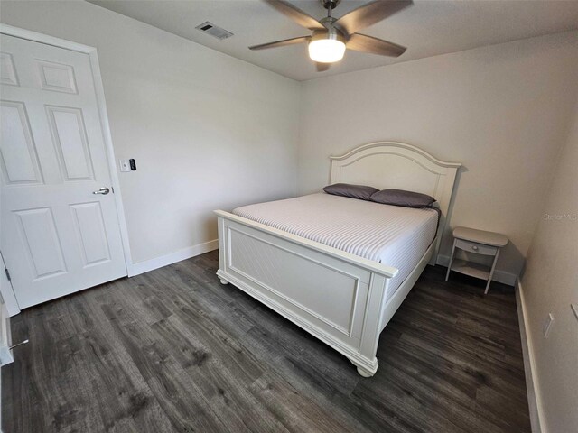 bedroom with dark hardwood / wood-style flooring and ceiling fan