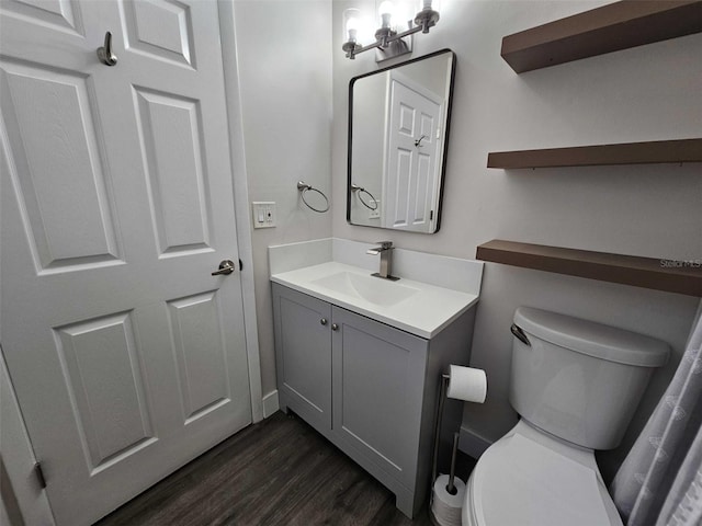 bathroom featuring vanity, toilet, and hardwood / wood-style floors