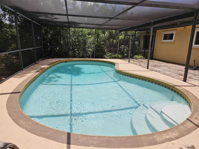 view of swimming pool featuring a lanai and a patio area