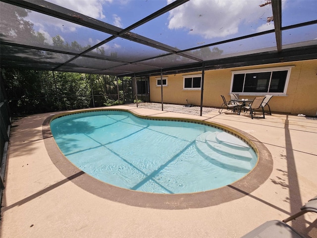 view of swimming pool with a patio area and glass enclosure