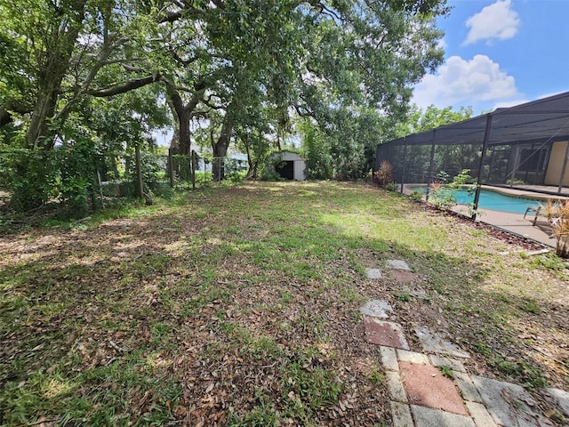 view of yard featuring a lanai and a storage shed