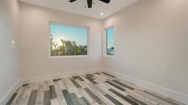 empty room with ceiling fan and light hardwood / wood-style flooring