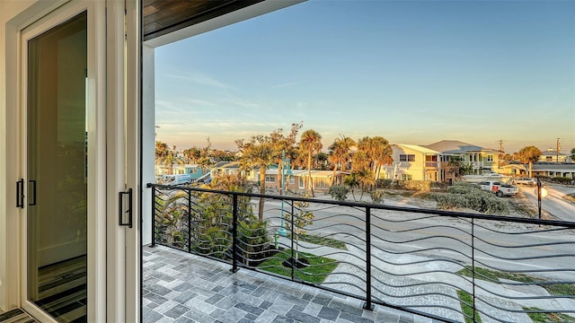 balcony at dusk featuring a residential view