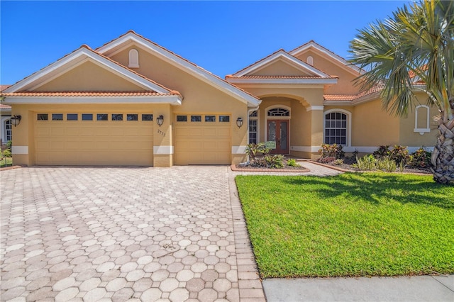 2773 Harvest Dr, Sarasota, FL 34240 - view of front of house featuring a tile roof, stucco siding, an attached garage, decorative driveway, and a front yard