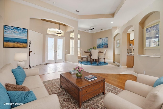 2773 Harvest Dr, Sarasota, FL 34240 - living room with light wood finished floors, baseboards, a ceiling fan, arched walkways, and french doors
