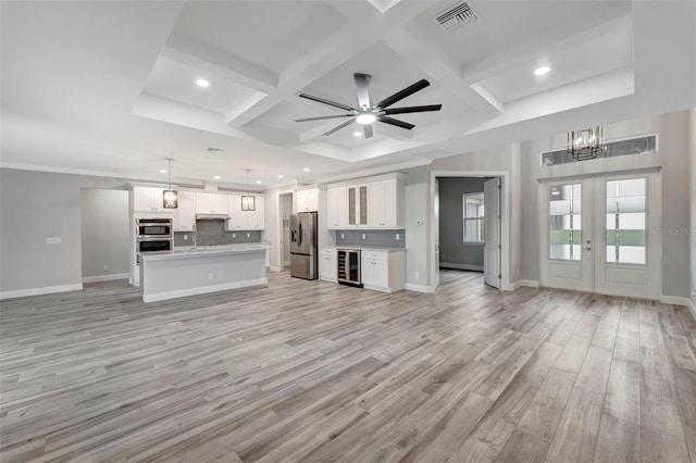 unfurnished living room with wine cooler, french doors, coffered ceiling, light wood-type flooring, and beam ceiling